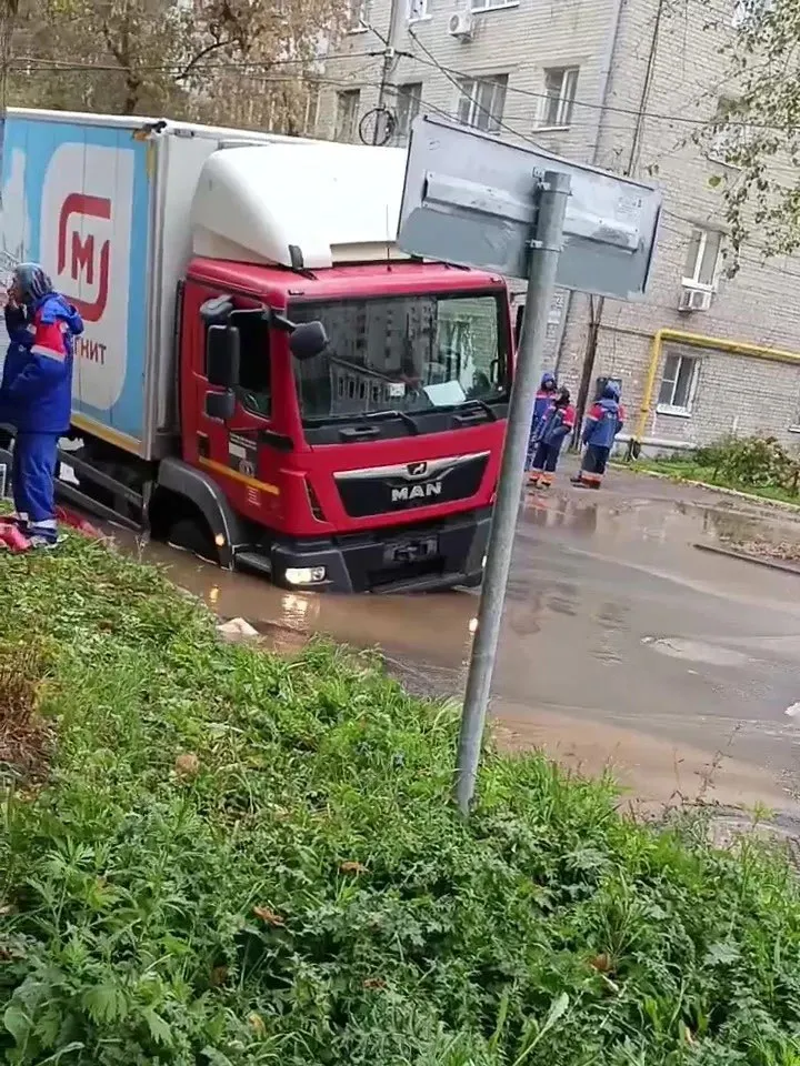На месте проводится устранение утечки водопроводной линии; грузовик извлекли с помощью спецтехники.